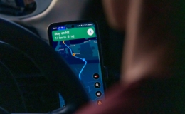 Pengemudi mobil memantau rute perjalanan lewat peta di ponsel
