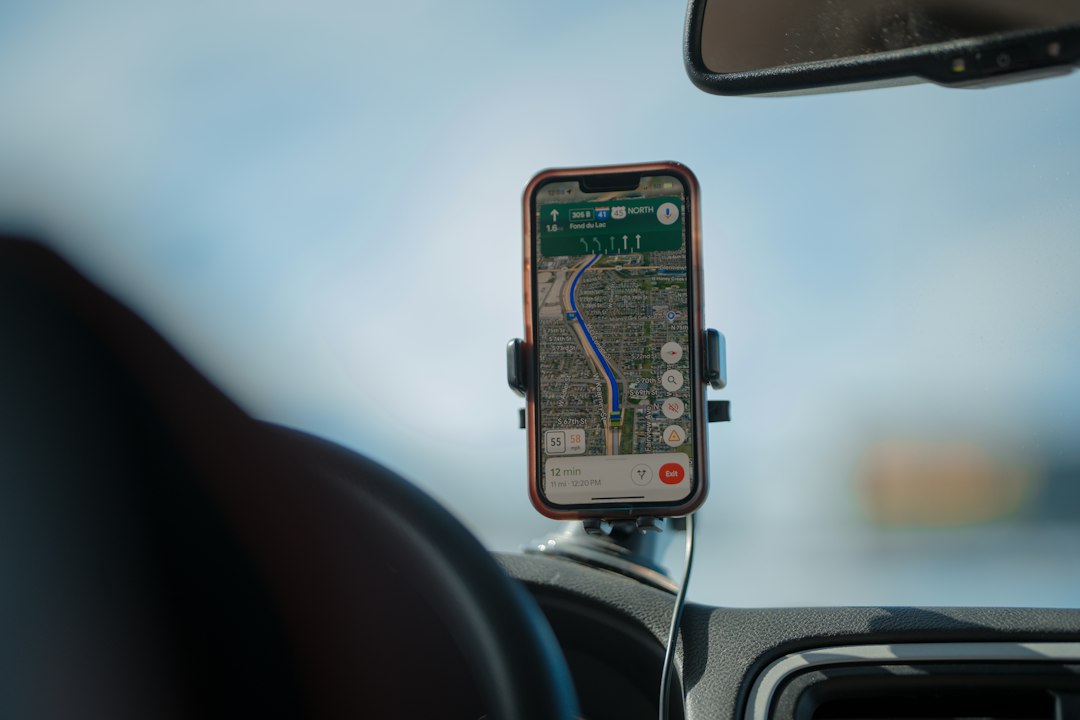 Layar peta GPS terpasang di dasbor mobil saat pengemudi melaju di jalan raya